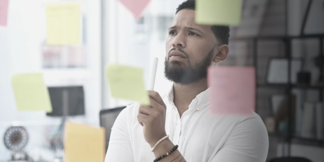 man in white shirt looking at post it notes
