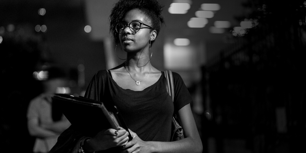 woman holding books looking into the distance